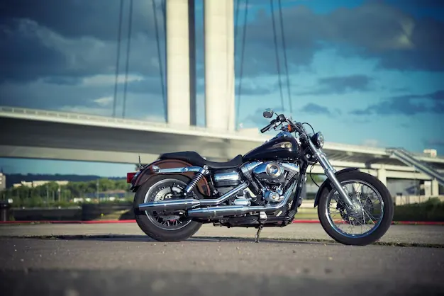 Harley-Davidson motorcycle parked beneath a bridge in Manama